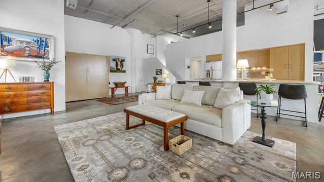 4100 Laclede Ave Unit 314, Saint Louis, MO 63108 - living area with a high ceiling, ornate columns, rail lighting, and concrete flooring