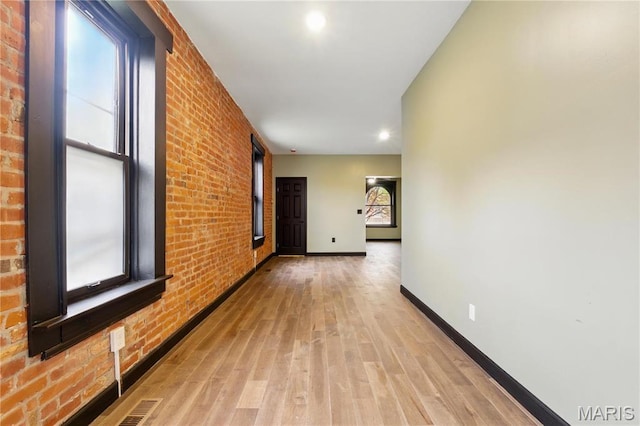 4402 Arco Ave, Saint Louis, MO 63110 - hall with baseboards, brick wall, light wood-style floors, and recessed lighting