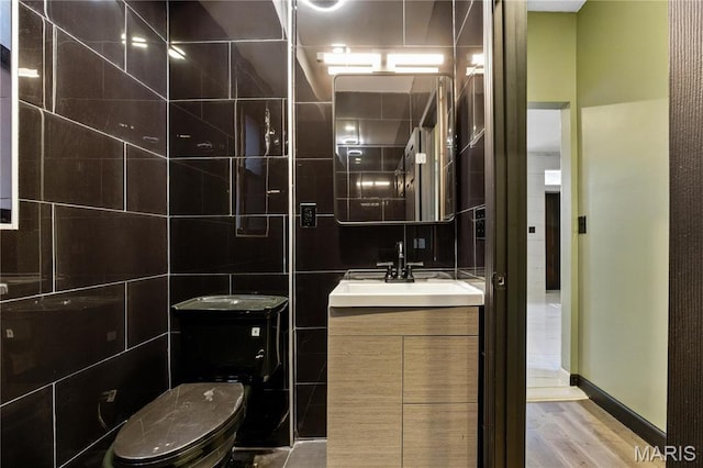 4402 Arco Ave, Saint Louis, MO 63110 - bathroom featuring tile walls, vanity, wood finished floors, and toilet