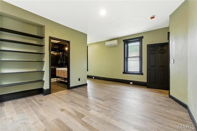4402 Arco Ave, Saint Louis, MO 63110 - spare room featuring a wall unit AC, wood finished floors, and baseboards