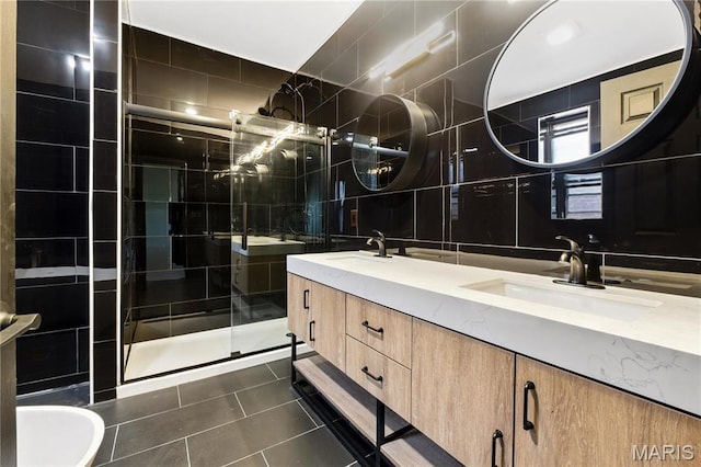 4402 Arco Ave, Saint Louis, MO 63110 - bathroom with tile walls, a shower stall, tile patterned flooring, double vanity, and decorative backsplash