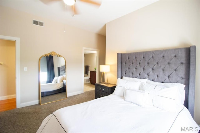 carpeted bedroom featuring ceiling fan, ensuite bathroom, and baseboards