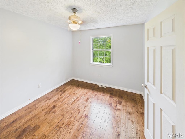 14075 Howard Ln, Dixon, MO 65459 - empty room with wood finished floors, a ceiling fan, baseboards, and a textured ceiling