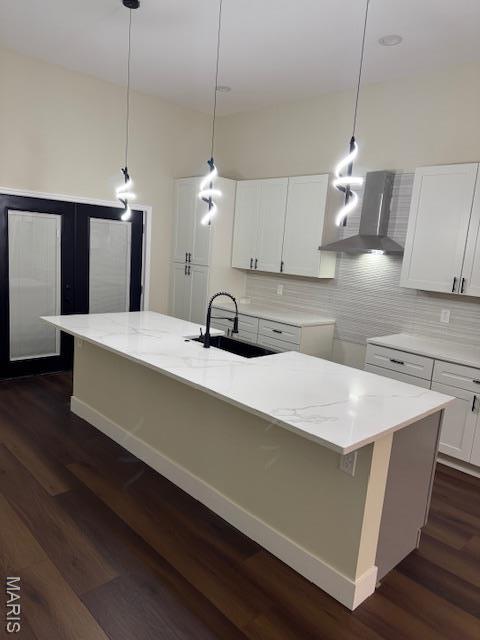 4209 Norfolk Ave, Saint Louis, MO 63110 - kitchen featuring a sink, wall chimney range hood, backsplash, white cabinetry, and light stone counters