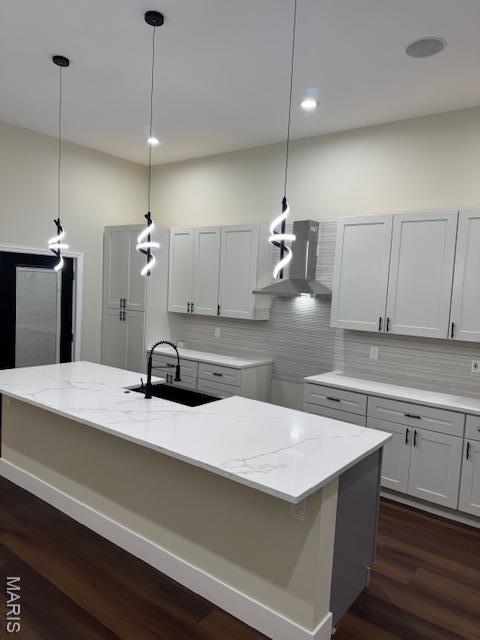 4209 Norfolk Ave, Saint Louis, MO 63110 - kitchen featuring wall chimney range hood, dark wood-style flooring, a sink, decorative backsplash, and decorative light fixtures