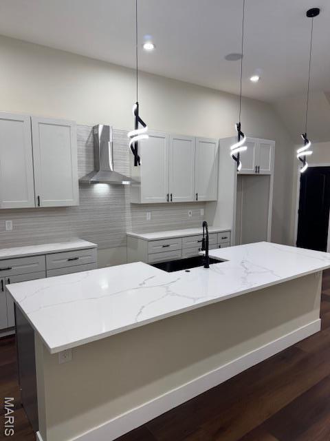 4209 Norfolk Ave, Saint Louis, MO 63110 - kitchen featuring wall chimney range hood, tasteful backsplash, light stone counters, a sink, and recessed lighting