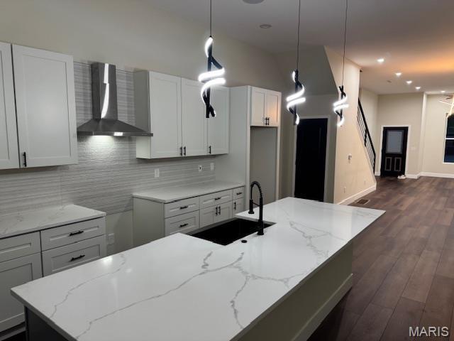 4209 Norfolk Ave, Saint Louis, MO 63110 - kitchen with wall chimney exhaust hood, a sink, decorative backsplash, light stone counters, and dark wood-type flooring
