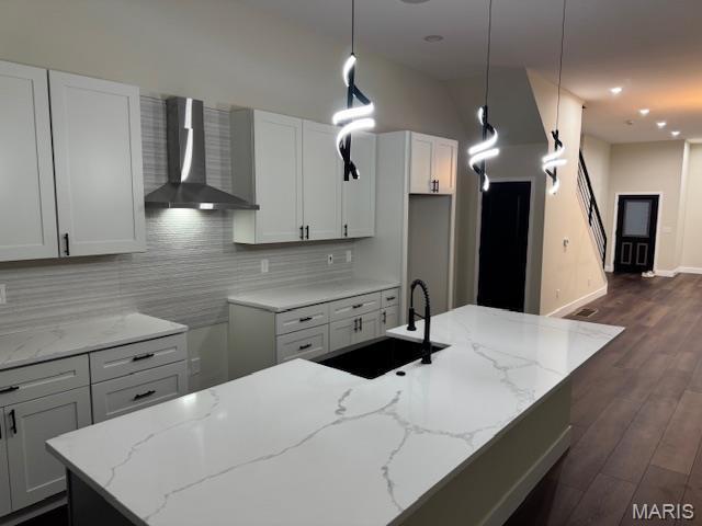 4209 Norfolk Ave, Saint Louis, MO 63110 - kitchen with wall chimney range hood, a sink, decorative backsplash, and light stone counters