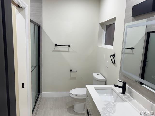 4209 Norfolk Ave, Saint Louis, MO 63110 - full bathroom featuring toilet, vanity, a shower with door, and baseboards