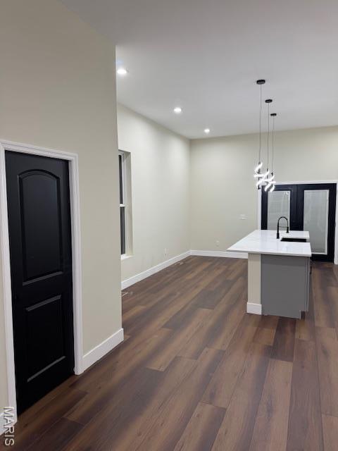 4209 Norfolk Ave, Saint Louis, MO 63110 - kitchen with dark wood finished floors, baseboards, light countertops, recessed lighting, and an island with sink