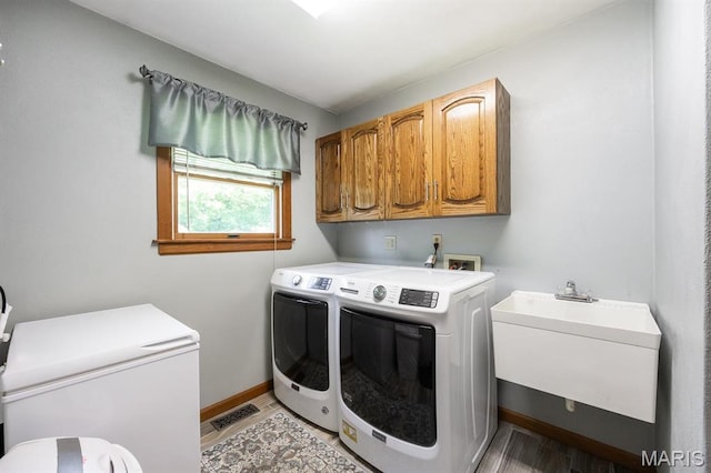 505 Turtle Creek Ct, Ofallon, IL 62269 - washroom with washing machine and clothes dryer, cabinet space, baseboards, and light wood-style floors
