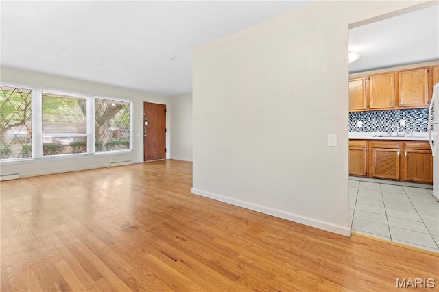 unfurnished living room featuring light wood-style floors and baseboards