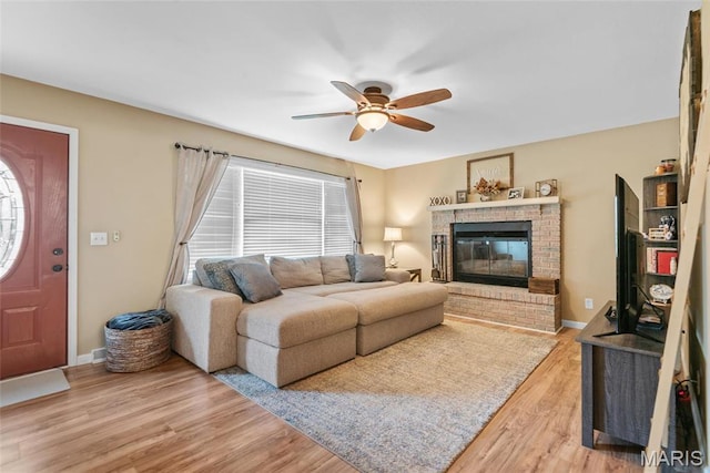 2212 Dawn Pl, Granite City, IL 62040 - living room featuring ceiling fan, light wood-style floors, a brick fireplace, and baseboards