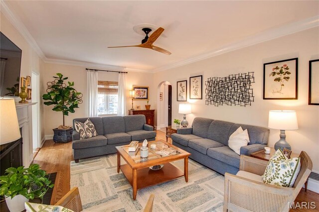 1210 Mckinley Blvd, Alton, IL 62002 - living room with arched walkways, ceiling fan, light wood-style flooring, crown molding, and baseboards