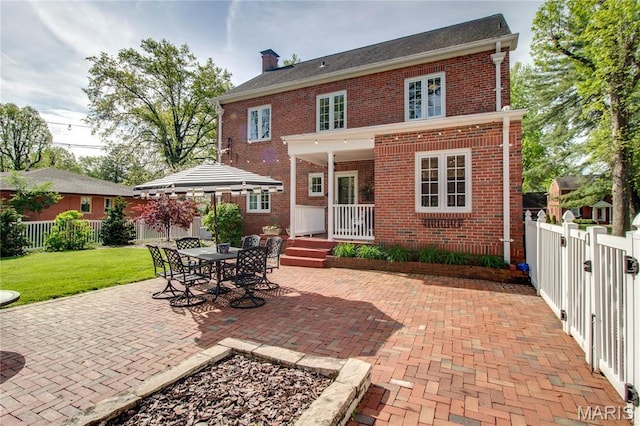 1210 Mckinley Blvd, Alton, IL 62002 - back of property featuring brick siding, a chimney, and a patio