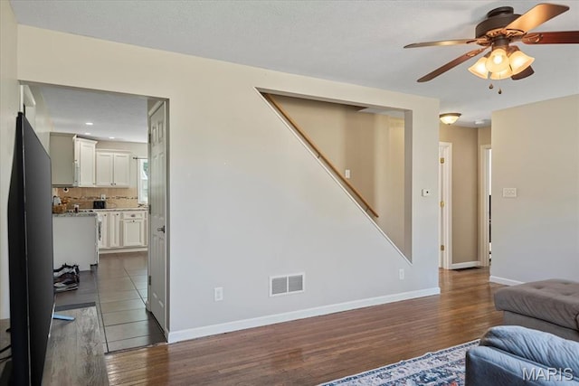 714 W Elm St, Taylorville, IL 62568 - living area with dark wood-style flooring, a ceiling fan, stairs, and baseboards