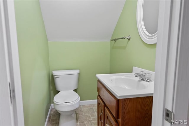 714 W Elm St, Taylorville, IL 62568 - bathroom featuring toilet, vanity, baseboards, and stone finish floors