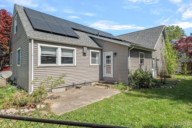 714 W Elm St, Taylorville, IL 62568 - back of property with solar panels, a shingled roof, and a patio area