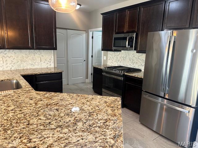 203 Chadwyck Cir, Herculaneum, MO 63048 - kitchen featuring stainless steel appliances, light stone countertops, tasteful backsplash, and dark brown cabinets