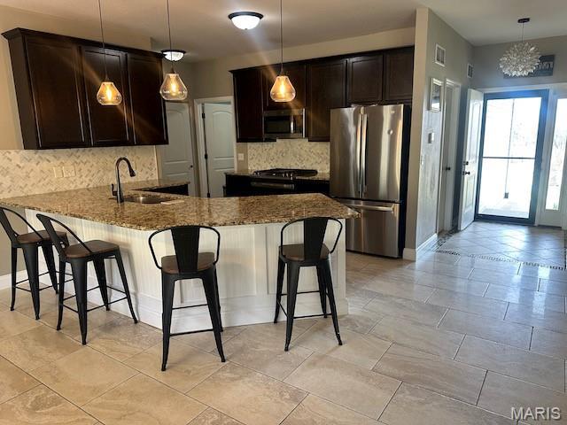 203 Chadwyck Cir, Herculaneum, MO 63048 - kitchen with stainless steel appliances, a sink, stone countertops, and tasteful backsplash