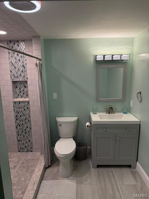 203 Chadwyck Cir, Herculaneum, MO 63048 - bathroom with toilet, vanity, a tile shower, and baseboards