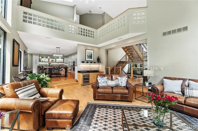 400 Gabriel Dr, Kirkwood, MO 63122 - living room featuring beverage cooler, light wood-style flooring, a towering ceiling, and stairway