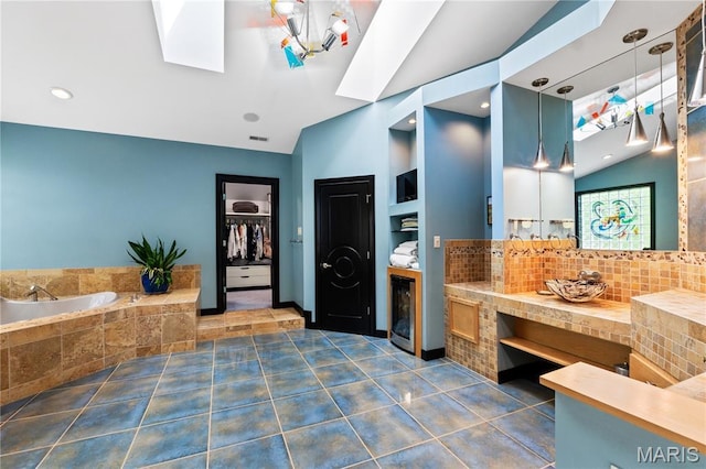 400 Gabriel Dr, Kirkwood, MO 63122 - full bath with a skylight, vaulted ceiling, backsplash, a garden tub, and tile patterned floors