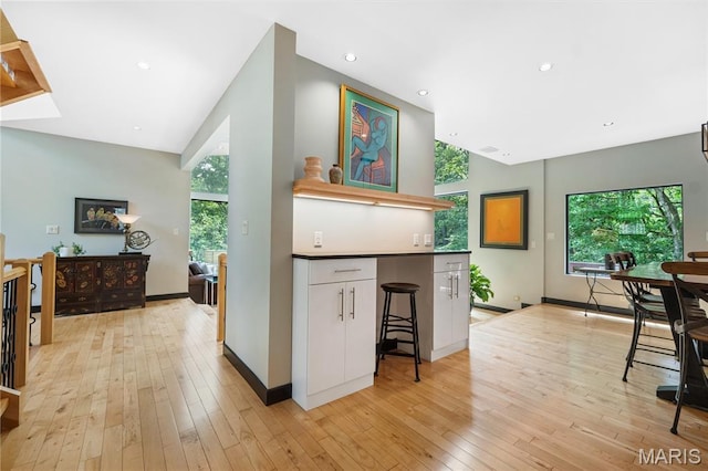 400 Gabriel Dr, Kirkwood, MO 63122 - kitchen featuring white cabinets, lofted ceiling, healthy amount of natural light, light wood-style floors, and recessed lighting