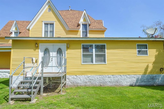 view of front of home featuring a front lawn and a shingled roof