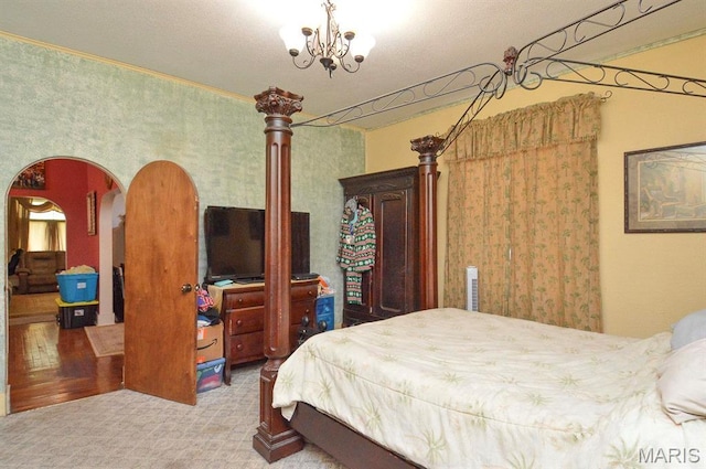 bedroom featuring a chandelier, carpet floors, and arched walkways