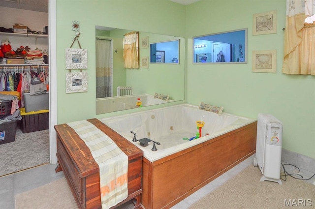 bathroom with radiator heating unit, a whirlpool tub, a spacious closet, tile patterned floors, and a shower