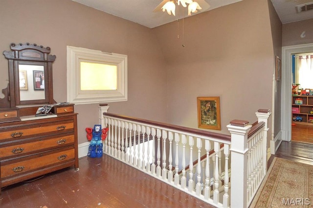hall with an upstairs landing and dark wood finished floors