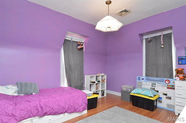 bedroom featuring wood finished floors and baseboards