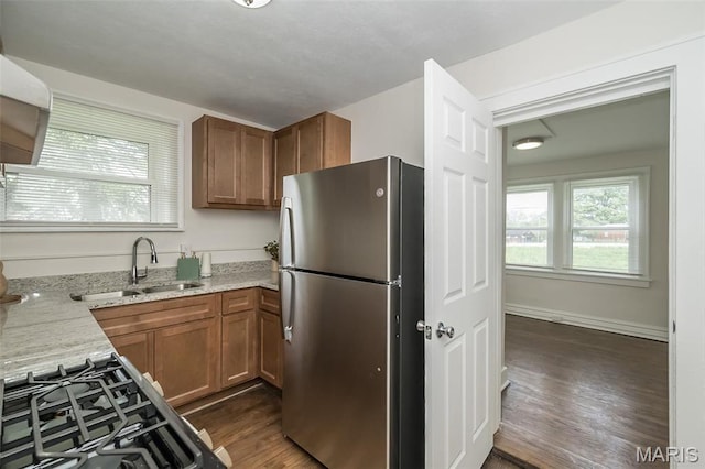 4117 Ravenwood Ave, Saint Louis, MO 63121 - kitchen with freestanding refrigerator, a sink, dark wood-style floors, light stone countertops, and brown cabinetry
