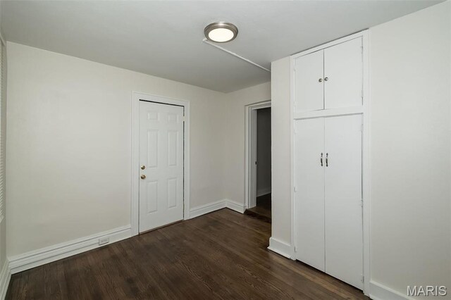 4117 Ravenwood Ave, Saint Louis, MO 63121 - unfurnished bedroom with dark wood-style floors, baseboards, and a closet
