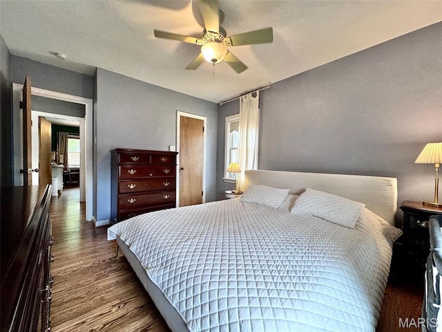 bedroom with wood finished floors, baseboards, and ceiling fan