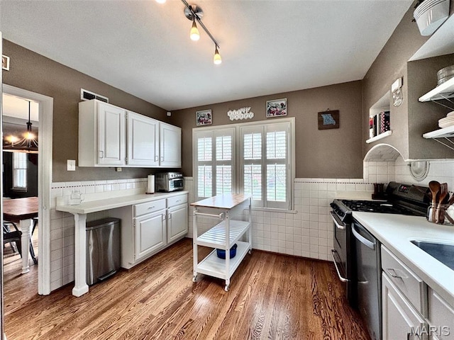 kitchen with open shelves, tile walls, stainless steel dishwasher, light countertops, and gas stove