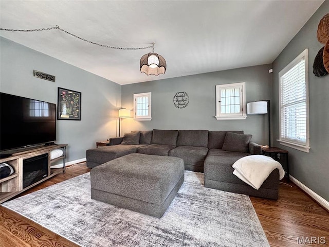 living room with plenty of natural light, wood finished floors, and baseboards