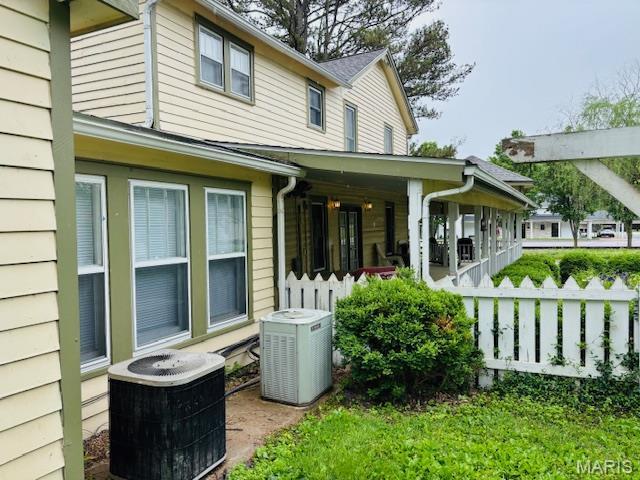 305 Frisco St, Steelville, MO 65565 - rear view of house featuring central air condition unit, a porch, and fence