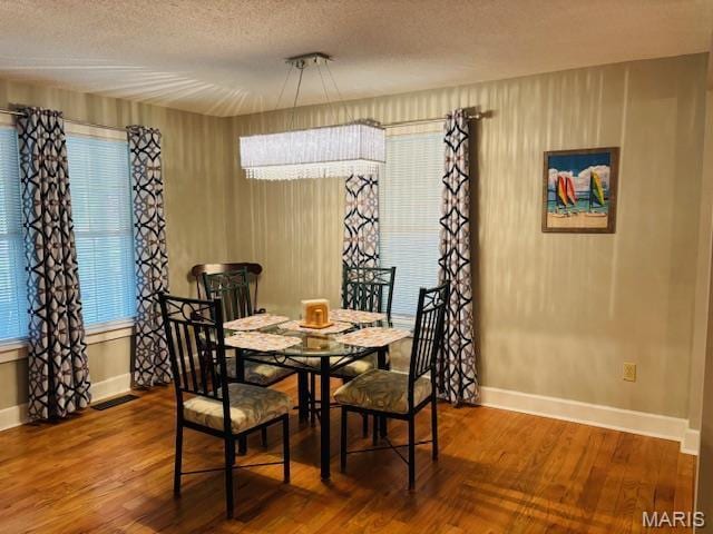 305 Frisco St, Steelville, MO 65565 - dining room featuring wood finished floors, baseboards, and a textured ceiling