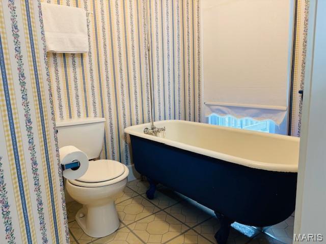 305 Frisco St, Steelville, MO 65565 - full bathroom featuring toilet, tile patterned flooring, and a freestanding tub
