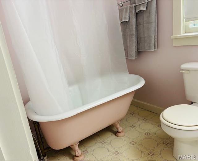 305 Frisco St, Steelville, MO 65565 - bathroom with toilet, a soaking tub, and baseboards
