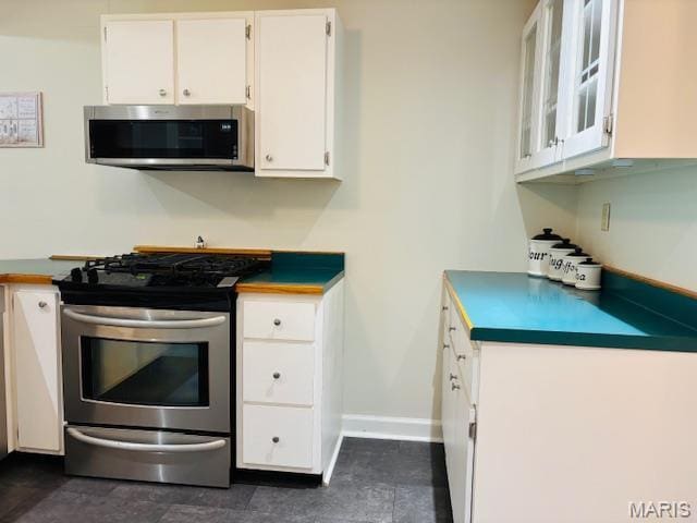 305 Frisco St, Steelville, MO 65565 - kitchen with appliances with stainless steel finishes, white cabinets, dark countertops, baseboards, and glass insert cabinets