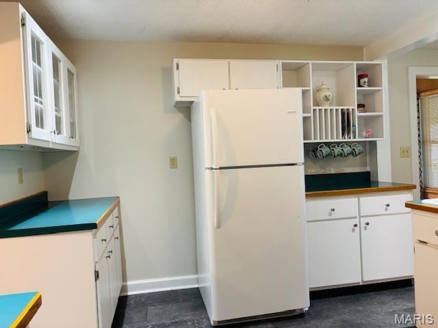 305 Frisco St, Steelville, MO 65565 - kitchen with freestanding refrigerator, white cabinetry, open shelves, baseboards, and glass insert cabinets