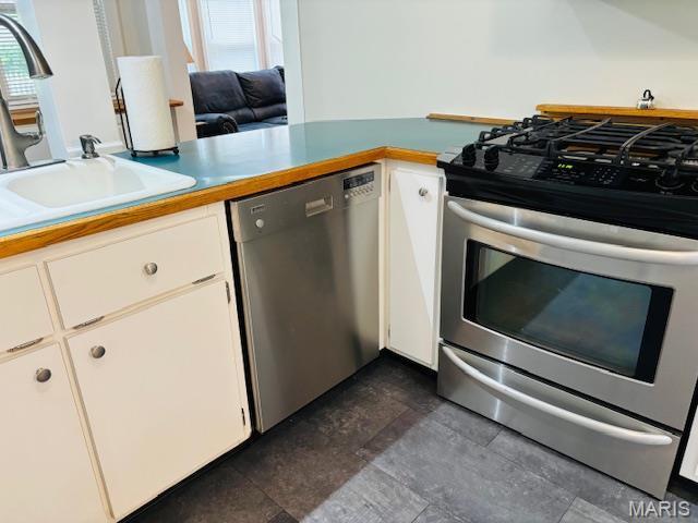 305 Frisco St, Steelville, MO 65565 - kitchen with stainless steel appliances, a sink, and white cabinetry