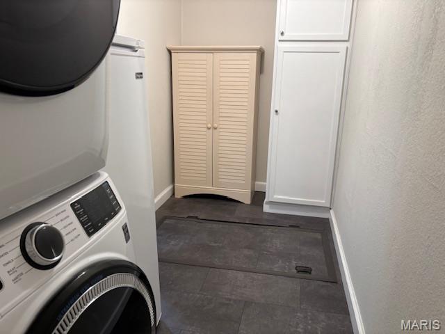 305 Frisco St, Steelville, MO 65565 - laundry room with stacked washer and clothes dryer, cabinet space, and baseboards