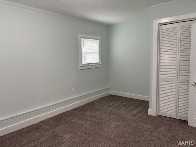 305 Frisco St, Steelville, MO 65565 - unfurnished bedroom featuring dark carpet, a closet, a textured ceiling, and baseboards