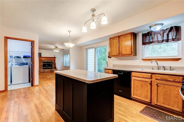 1101 Nathaniel Ct, Hazelwood, MO 63042 - kitchen with black dishwasher, a ceiling fan, a center island, a sink, and a fireplace