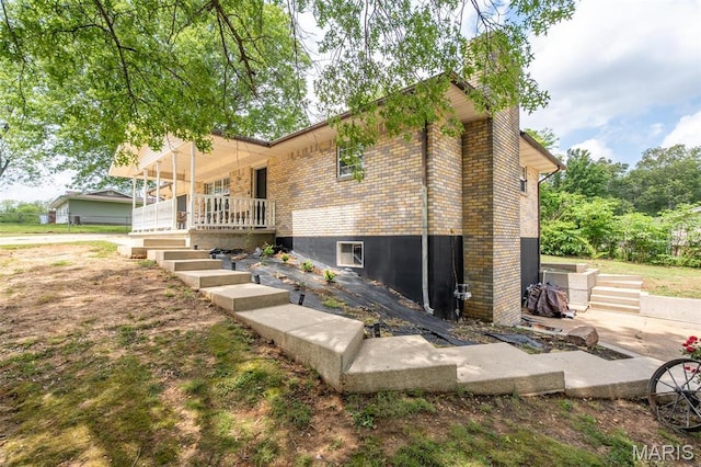 2003 Kysar Rd, Poplar Bluff, MO 63901 - view of side of home with brick siding, a porch, and a chimney
