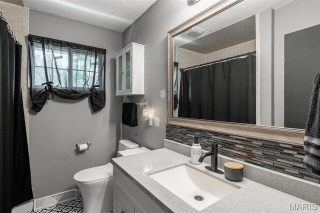 2003 Kysar Rd, Poplar Bluff, MO 63901 - full bathroom with tasteful backsplash, toilet, vanity, a textured ceiling, and tile patterned flooring